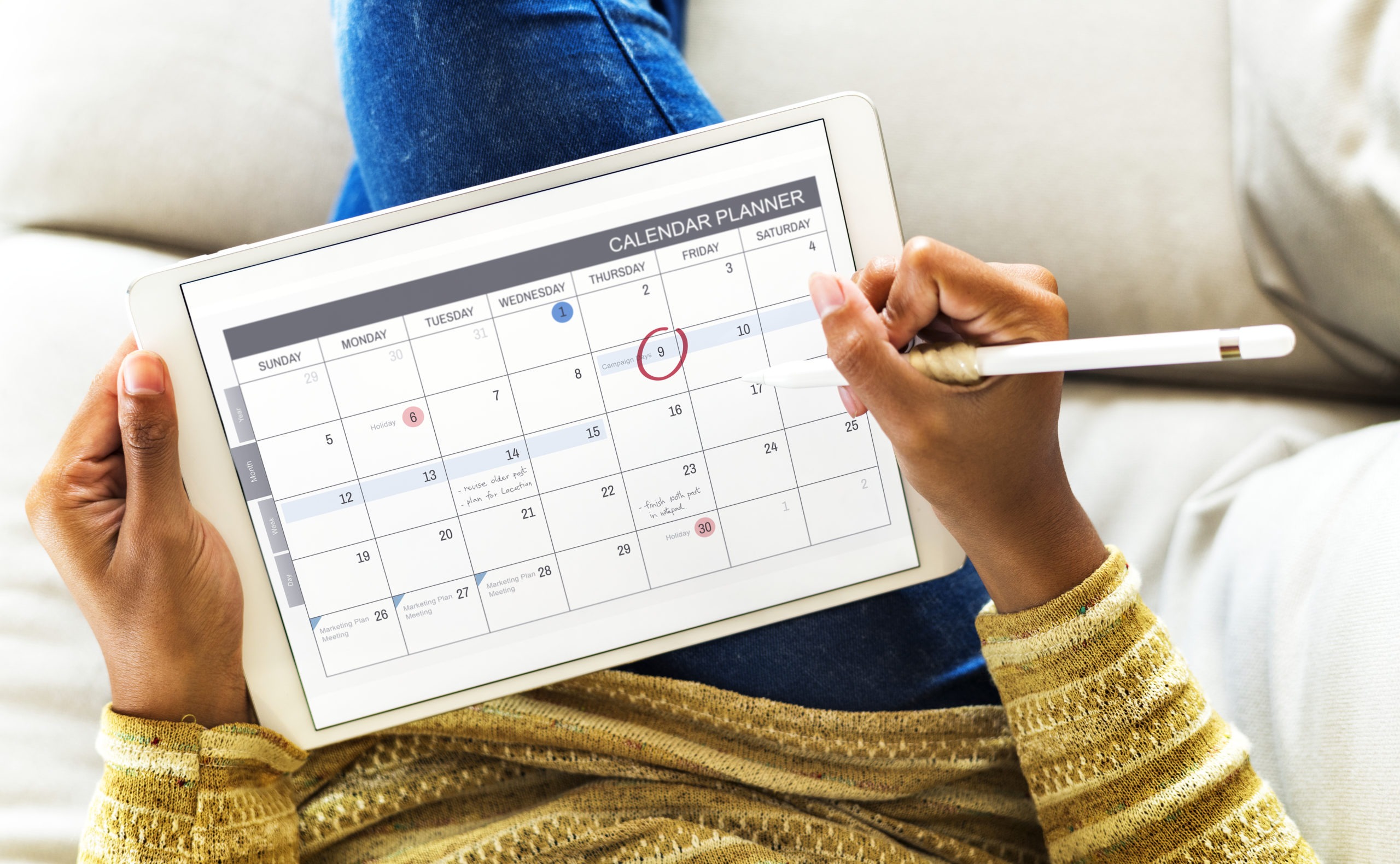 woman checking calendar on digital tablet PTYMU2E scaled