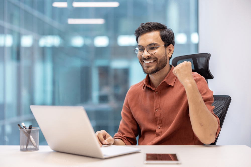 happy office worker celebrating success at desk wi 2025 03 25 16 21 17 utc
